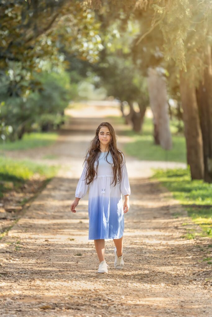 צילומי בת מצווה מתבגרת עם בפארק הולכת בשביל