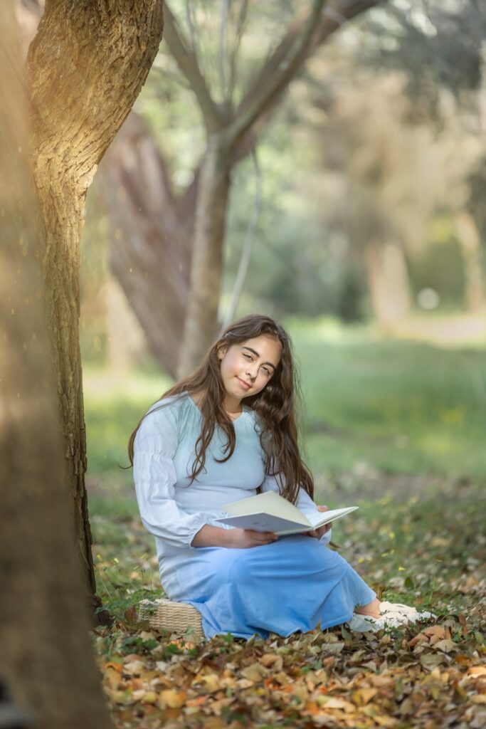 צילומי בת מצווה מתבגרת עם בפארק יושבת ברצפה