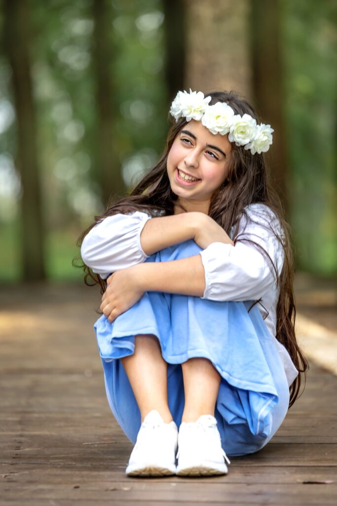 צילומי בת מצווה מתבגרת עם בפארק יושבת ברצפה