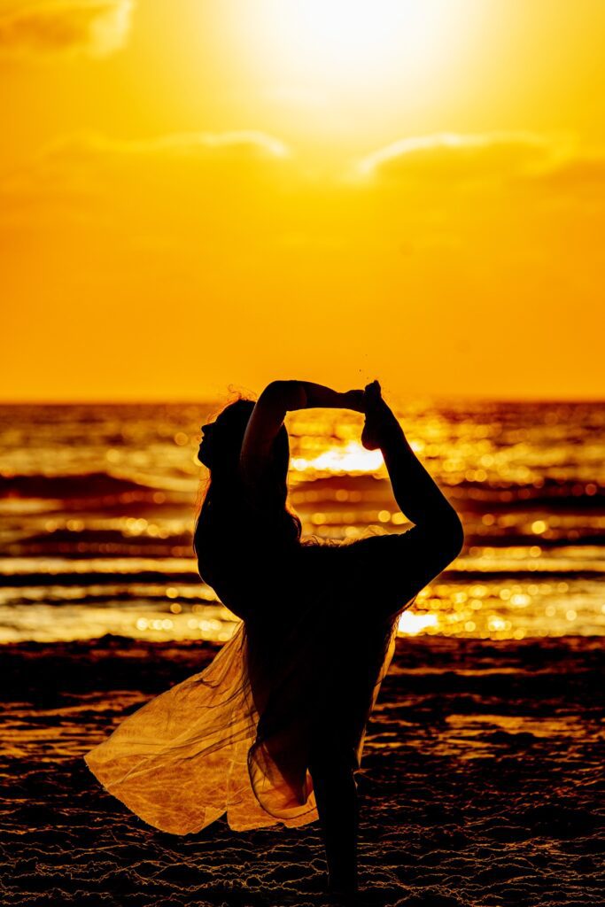 תמונת בת מצווה של מתבגרת על חוף הים עם תרגיל אקרובטי