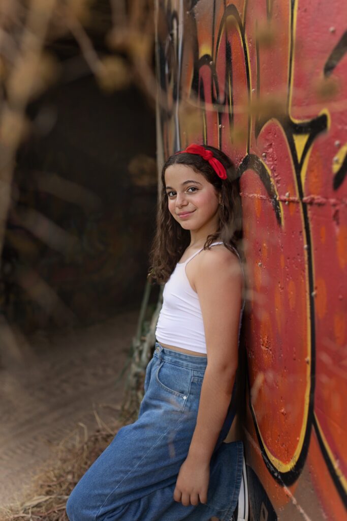 צילומי בת מצווה מתבגרת נשענת יעל קיר מצויר