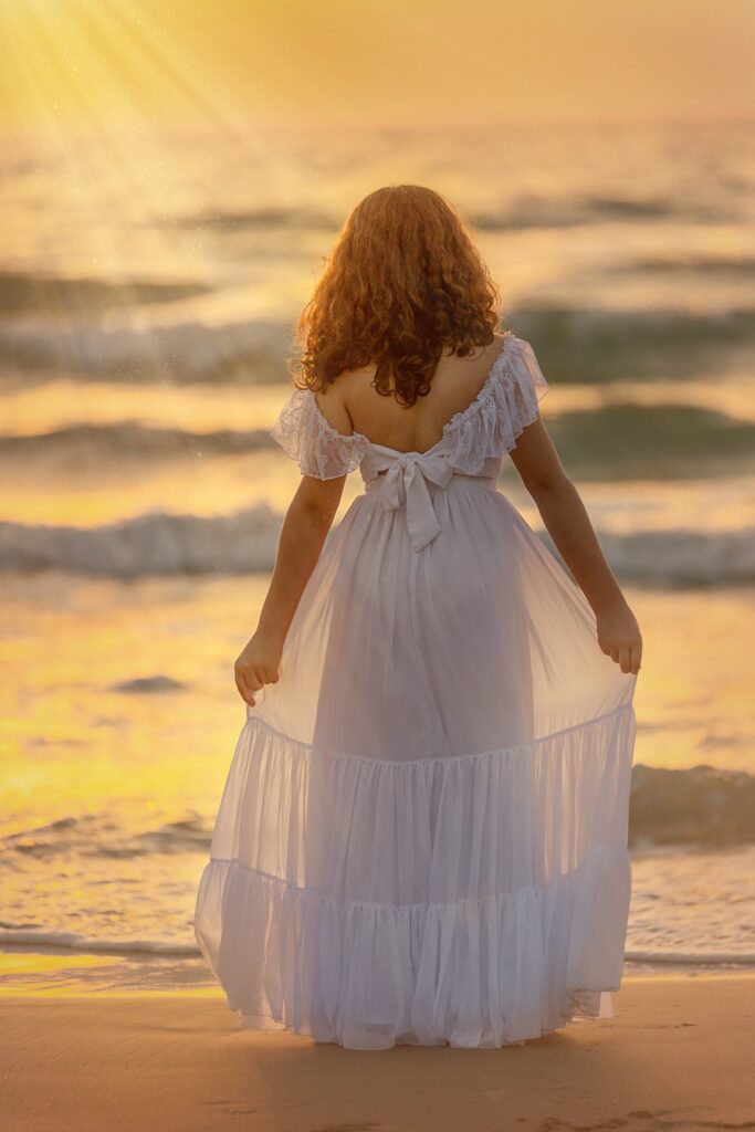 תמונת בת מצווה של מתבגרת על חוף הים עם הגב למצלמה