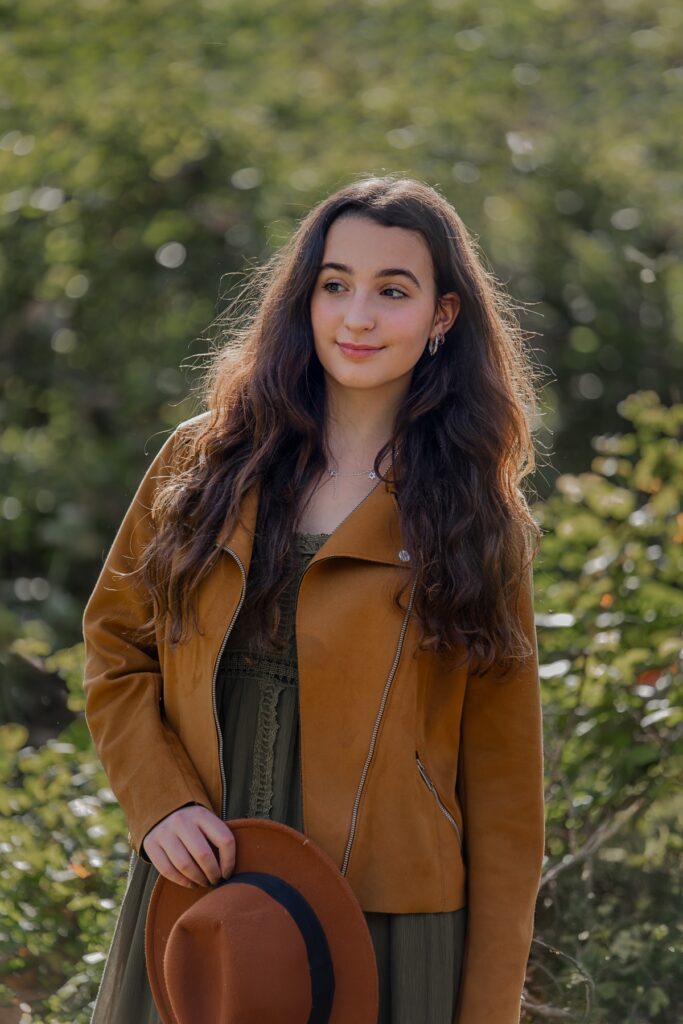 צילומי בת מצווה מתבגרת עם עם כובע ביד