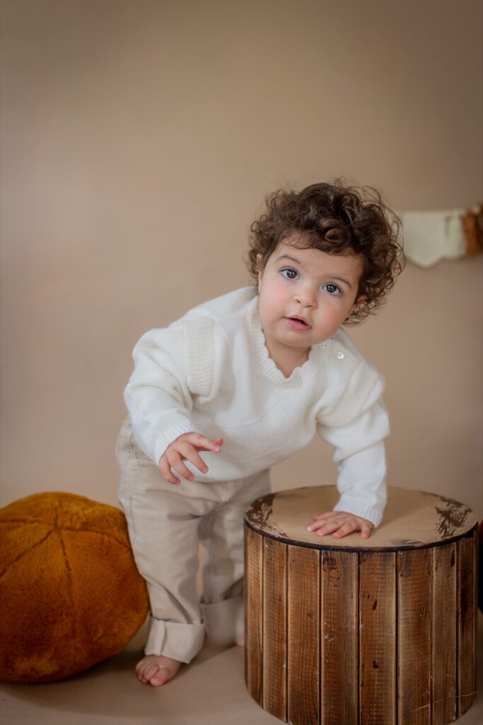 גיל שנה - פעוט מסתכל למצלמה נשאן על גזע .