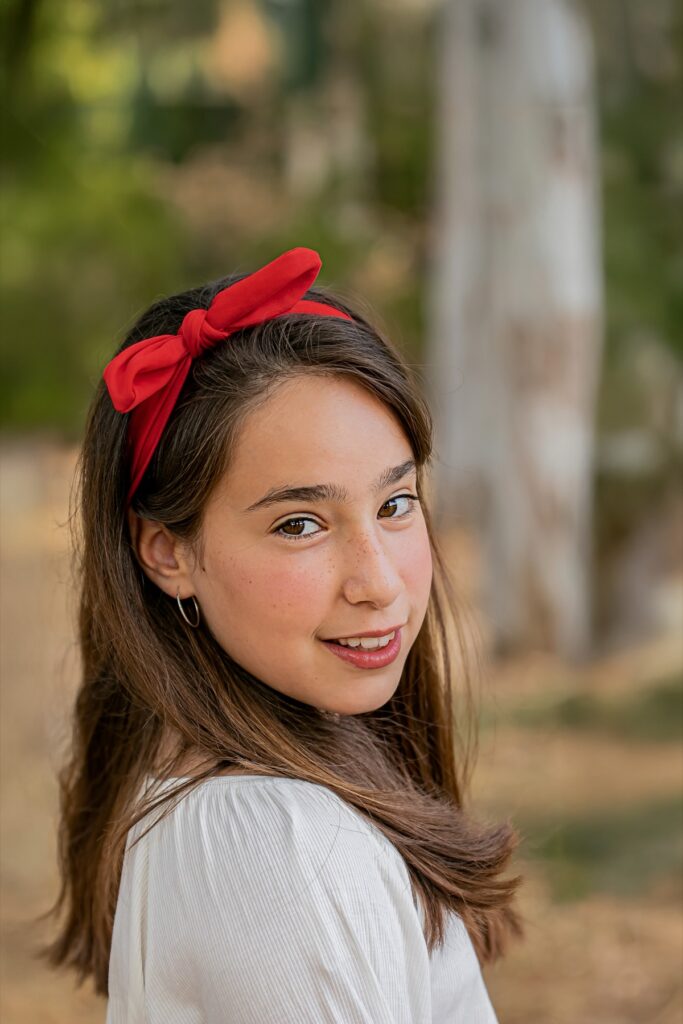 צילומי בת מצווה מתבגרת עם סרט אדום על הראש