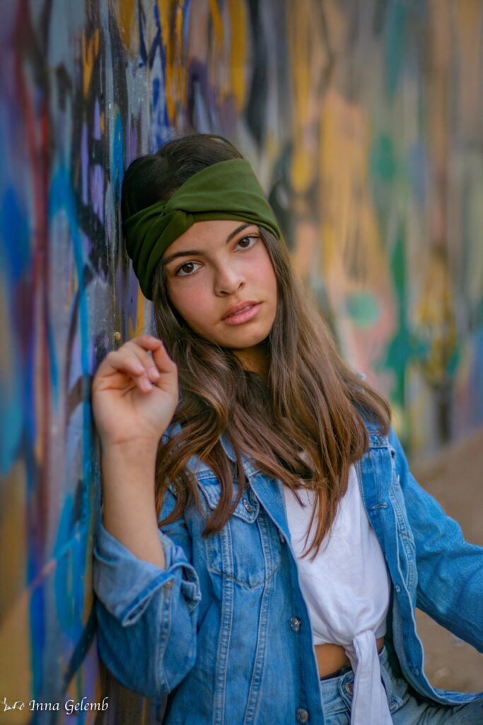 צילומי בת מצווה מתבגרת נשענת מאחורי קיר מצויר