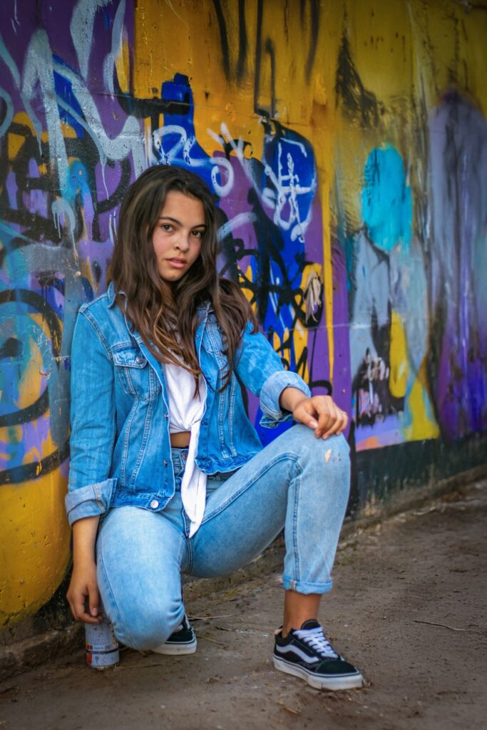 צילומי בת מצווה מתבגרת יושבת מאחורי קיר מצויר