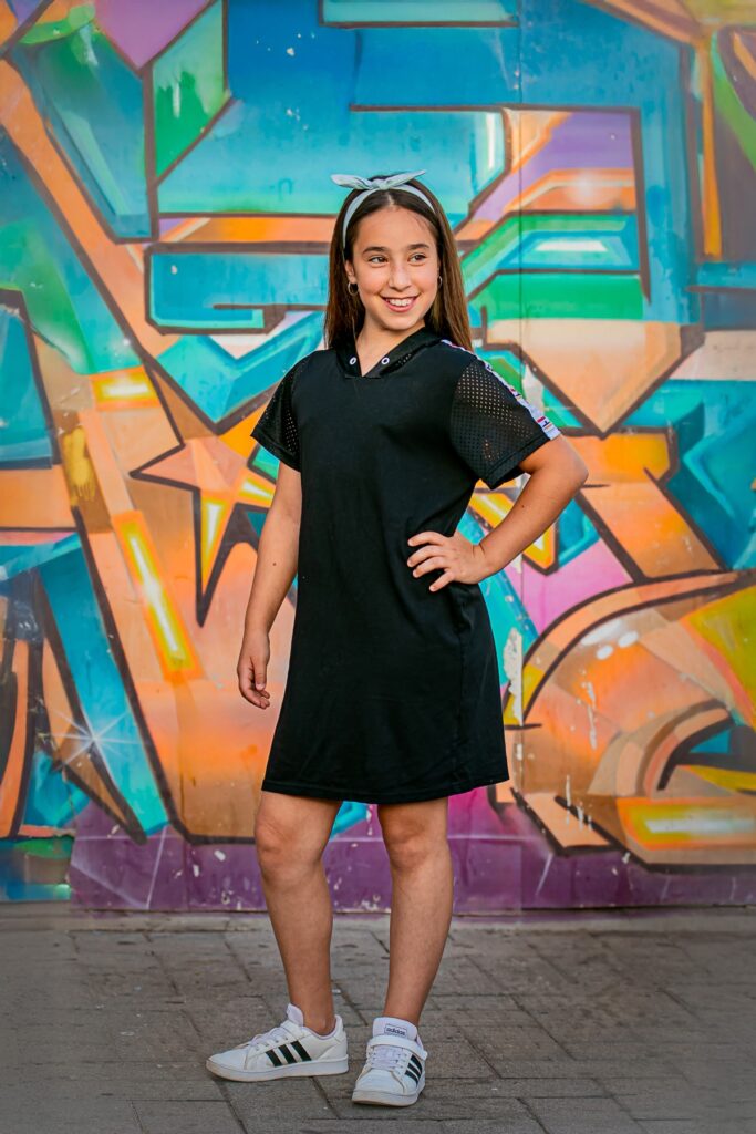 צילומי בת מצווה מתבגרת עומדת מאחורי קיר מצויר