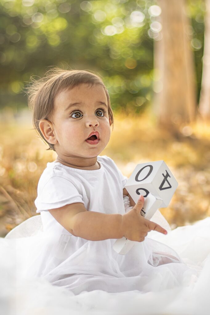 תמונה גיל שנה תמונה של תינוקת מחזיקה קובייה עם מיספרים 0 ו4 בטבע
