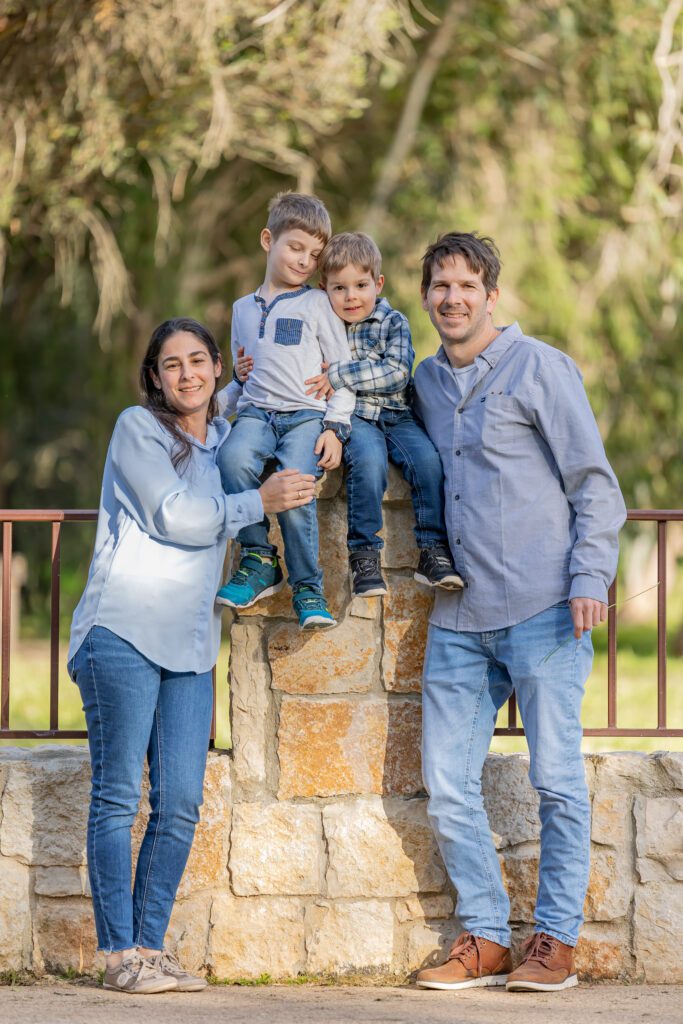 צילומי משפחה שתי ילדים יושבים על עמוד עם שני הילדים סביבם