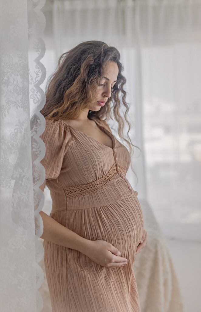 אישה מסתכלת על הבטן עם ווילון